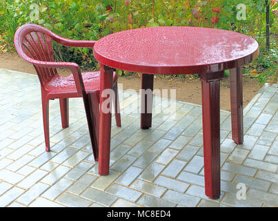 Plastic furniture during a rain on a patio Stock Photo