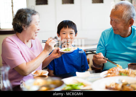 Grandmother feeding her grandson in restaurant Stock Photo