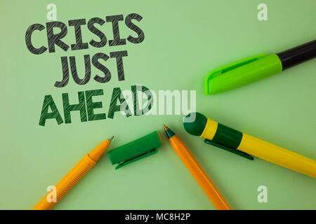 Handwriting text writing Crisis Just Ahead. Concept meaning Foresee failure take right action before it is late written Plain Green background Pens ne Stock Photo