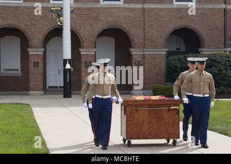 Barracks’ Marines march out with the birthday cake to commemorate the Barracks, and its illustrious history, at Marine Barracks Washington, Washington D.C., March 29, 2018. The Barracks hosted the celebration for its 217th Birthday at the parade deck, which included a cake cutting ceremony, and performances by the U.S. Marine Corps Color Guard and 'The President's Own' U.S. Marine Band. In attendance were Marine Corps veterans with the Center House Association and Marines of MBW. Stock Photo