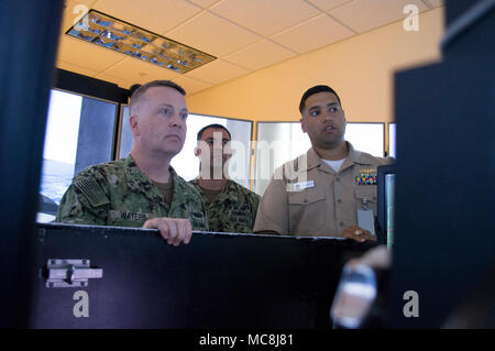 APRA HARBOR, Guam (April 2, 2018) Lt. Jeffrey Cornielle, officer in charge, Naval Submarine Training Center Pacific detachment Guam, right, discusses the capabilities of the Submarine Multi-Mission Team Trainer (SMMTT) with Rear Adm. James Waters III, director, Maritime Headquarters, U.S. Pacific Fleet, left, during a tour of the training facility, April 2. Also pictured is Lt. Dave Mina, Joint Region Marianas protocol office, center. Waters met with Navy commands across Guam to discuss ship maintenance and logistical capabilities and concerns. Stock Photo