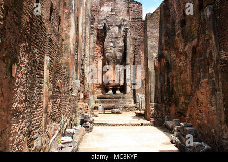 A giant masoned Standing Buddha statue without head in a temple in the royal ancient city of Polonnaruwa in Sri Lanka Stock Photo
