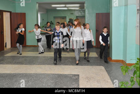 Gadjievo, Russia - September 19, 2012: The teacher walks with the children along the school corridor Stock Photo