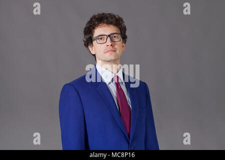 Nice man with glasses and curly hair wearing in blue suit Stock Photo
