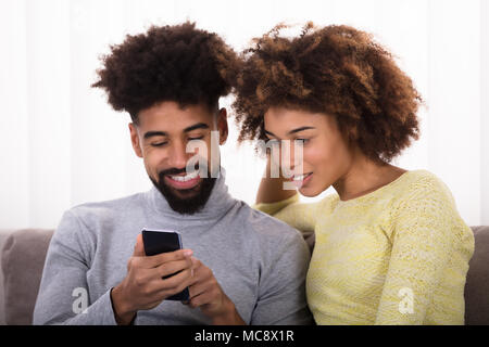 Close-up Of Young Happy Couple Looking At Mobile Phone Stock Photo