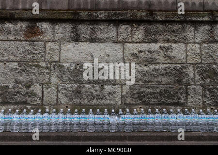 Water bottles lined up against a wall in a effort to keep cats away from the area. Sengoku, Tokyo, Japan. Stock Photo