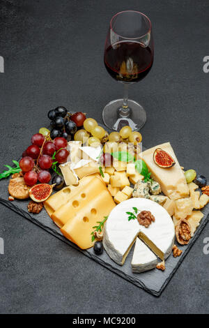 various types of cheese and wine on stone serving board Stock Photo