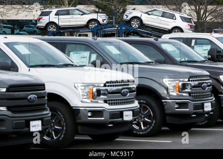 A row of new Ford F-series pick-up trucks and Explorer SUV's at a car dealership in Columbia, Maryland on April 13, 2018. Stock Photo