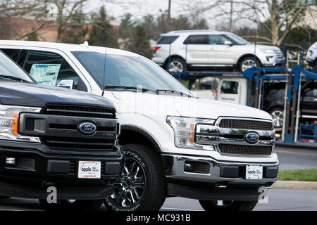A row of new Ford F-series pick-up trucks and Explorer SUV's at a car dealership in Columbia, Maryland on April 13, 2018. Stock Photo