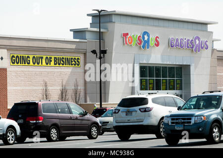 A logo sign outside of a joint Toys 'R' Us and Babies 'R' Us retail store in Columbia, Maryland with 'Going Out Of Business' signage on April 13, 2018 Stock Photo