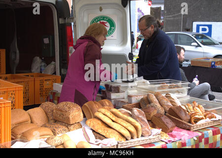 stall holder selling freshly baked bread at a local farmers food market, west cork, ireland. Stock Photo