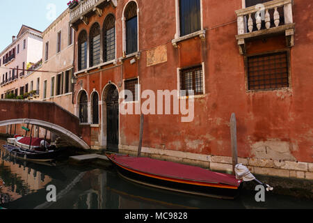 Venice, Italy - June, 21, 2013: Typical view of gondolas and boats covered with a special cloth on the canal of Venice. Old buildings around. Perfect  Stock Photo