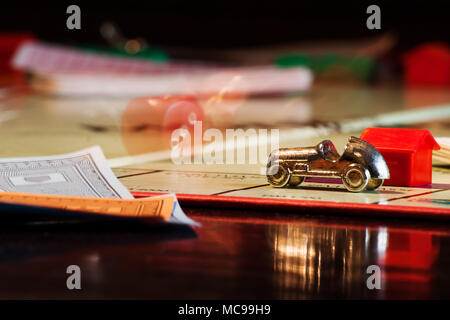 Salzburg, Austria - April 6 2010: Monopoly boardgame with rolling dice behind golden car and paper money Stock Photo