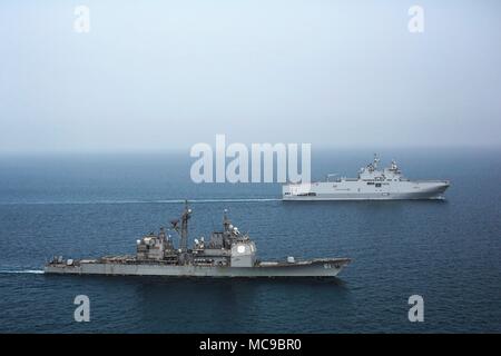 The French amphibious assault ship LHD Tonnerre (L9014), back, and the U.S. Navy guided-missile cruiser USS Monterey (CG 61) patrol the Persian Gulf January 25, 2018. The Tonnerre and Monterey took part in a joint cruise missile attack at chemical weapons targets in Syria April 14, 2018.  (US Navy Photo via Planetpix) Stock Photo