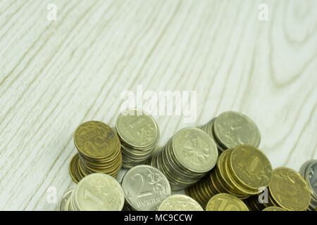 Coins of Russian courses are placed on a beige wooden background with one, two, .There is space for entering text Stock Photo