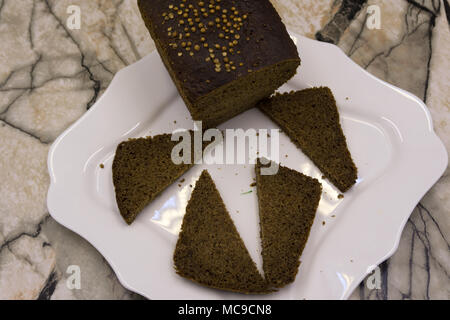 Cutting delicious homemade black bread. Borodinsky bread is a traditional Russian rye-wheat bread with maltose syrup, malt and coriander Stock Photo