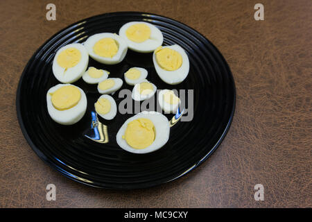two halves of boiled eggs on wooden rustic background. the view from the top Stock Photo