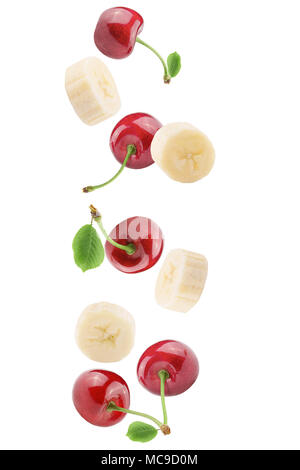 Isolated falling fruits. Falling  banana and  cherries isolated on white background with clipping path as package design element. Stock Photo
