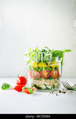Healthy salad jar with quinoa and vegetables, cherry tomatoes, cucumber, ruccola. Raw vegetarian meal for diet, detox, clean eating. Homemade concept. Stock Photo