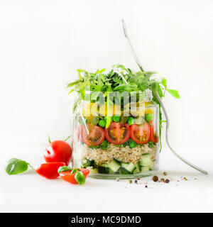 Healthy salad jar with quinoa and vegetables, cherry tomatoes, cucumber, ruccola. Raw vegetarian meal for diet, detox, clean eating. Homemade concept. Stock Photo