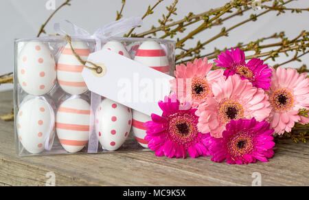 Easter eggs with dots and stripes with pink gerbera and white copy space Stock Photo