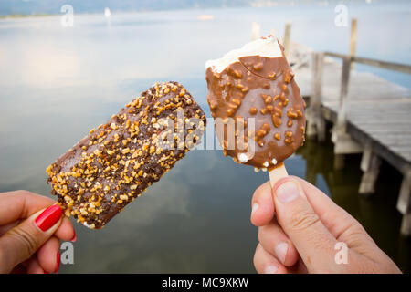 Ice cream covered with chocolate and almonds background. Stock Photo