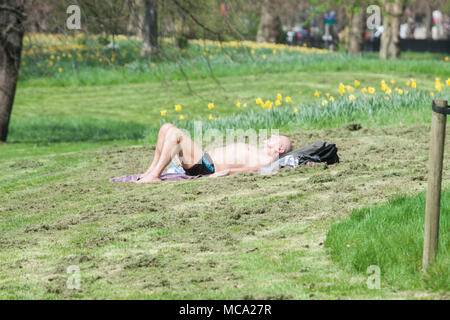 London, UK. 14 April 2018.A man sunbathes in Hyde Park  in the spring sunshine as  warmer temperatures are forecast over the weekend and next week across many parts of Britain Credit: amer ghazzal/Alamy Live News Credit: amer ghazzal/Alamy Live News Stock Photo