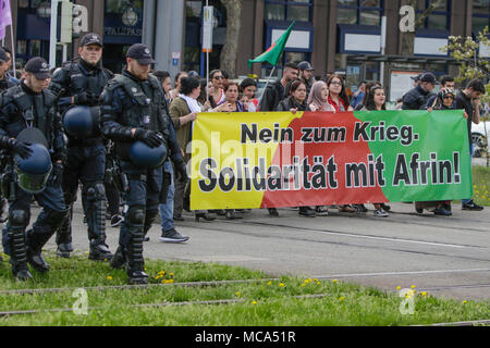 Mannheim, Germany. 14th April 2018. A large number of police officers escorts the protest march. Kurdish people and German supporters marched through Mannheim to protest against the continued occupation of the Syrian city of Afrin, which was controlled by the Kurdish Popular Protection Units (YPG) before it got conquered by the Turkish army. They also protested against the German involvement via weapons exports to Turkey. Credit: Michael Debets/Alamy Live News Stock Photo