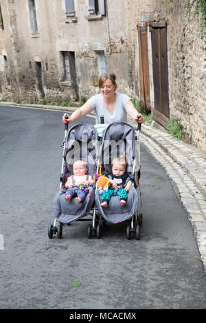 Young mum pushing a double buggy on holiday with twins Stock Photo Alamy