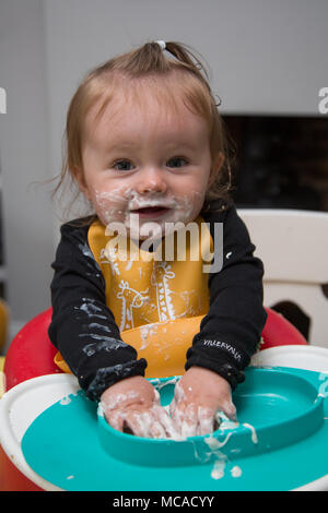 9 month old baby eating yoghurt - baby led weaning Stock Photo