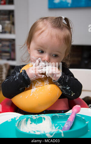 9 month old baby eating yoghurt - baby led weaning Stock Photo