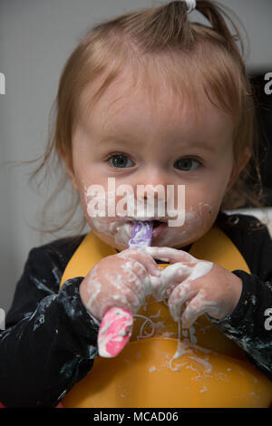 9 month old baby eating yoghurt - baby led weaning Stock Photo