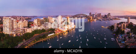 Pink sunset over Sydney city CBD landmarks around Sydney harbour connected by the Sydney harbour bridge in elevated aerial panorama from Lavender bay  Stock Photo