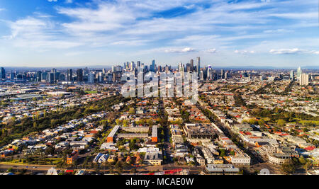 Leading streets and residential suburbs from Port Melbourne via Southbank to Melbourne city CBD against blue sky in aerial wide view. Stock Photo