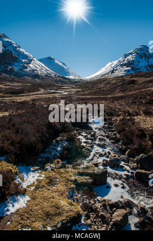 Breathtaking views of the Scottish Highlands - a bright sunshine shines down on the beautiful mountains of Glencoe Stock Photo