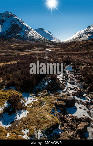 Breathtaking views of the Scottish Highlands - a bright sunshine shines down on the beautiful mountains of Glencoe Stock Photo