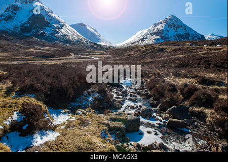 Breathtaking views of the Scottish Highlands - a bright sunshine shines down on the beautiful mountains of Glencoe Stock Photo