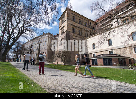 10 April 2018, Czech Republic, Prague: Tourists walk past the side wing (C) of the Prague castle. The castle was the seat of the Czech royalty and kings until the 16th Century. The window (middle row, 3rd R) was the site of the historic second 'Defenestration of Prague' which took place on 23 May 1618, marking the start of the 'Thirty Years' War', an important turning point in Europe's history. Photo: Monika Skolimowska/dpa-Zentralbild/dpa Stock Photo