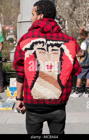 The back side of a man's spring jacket that has a rug-like portrait sewn on. In Union Square Park, Manhattan, New York City. Stock Photo