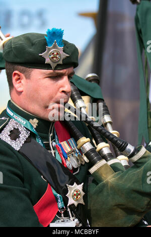 Uniformed musician of The Irish Guards or The Micks playing bagpipes. Foot Guards regiments of the British Army pipers & band at Aintree, Liverpool, UK Stock Photo
