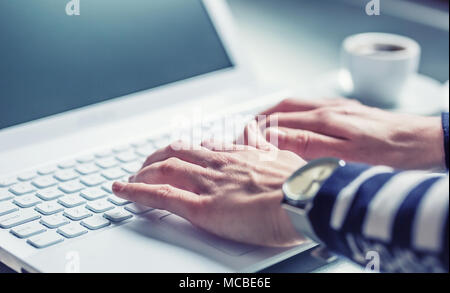 Woman hands typing on the keyboard of laptop, close-up of online working. Stock Photo