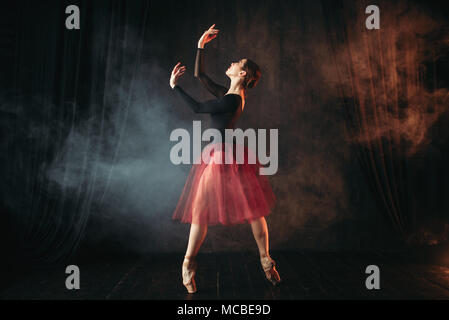 Ballet dancer in red dress dancing on the stage Stock Photo
