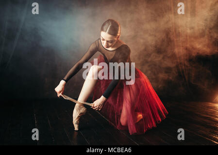 Ballet dancer tying pointe shoes Stock Photo