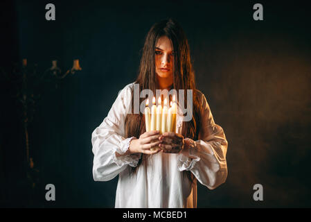 Female person holds candles in hands, divination Stock Photo