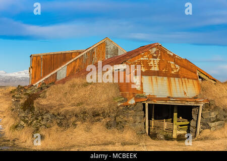 Old corrugated sheet metal barn bolstered on the sides with lava rocks ...