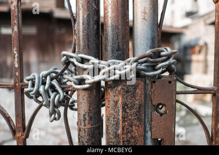 Rusty steel door locked with chain Stock Photo