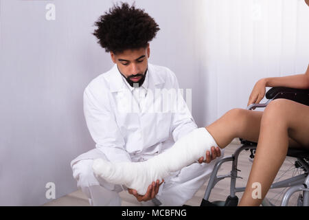 Close-up Of Doctor's Hand Holding Disabled Woman's Leg In Clinic Stock Photo