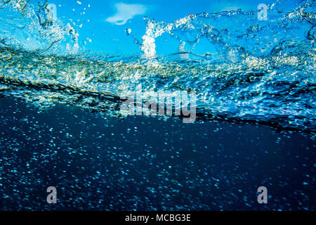 Shot of underwater ocean splash against blue sky. Stock Photo