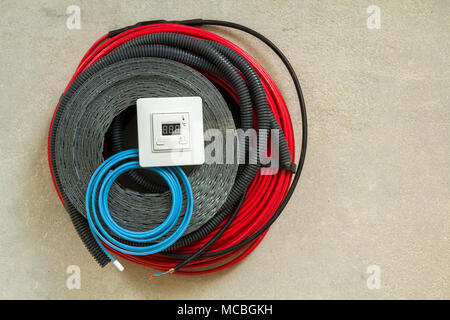 Heating floor system wires, cables and control panel. Renovation and construction concept. Comfort house. Stock Photo