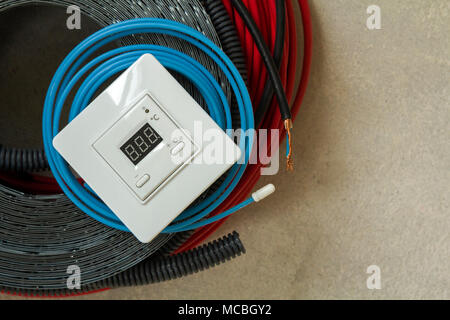 Heating floor system wires, cables and control panel. Renovation and construction concept. Comfort house. Stock Photo